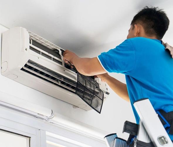 Radiant Airflows technician servicing a wall-mounted split AC unit